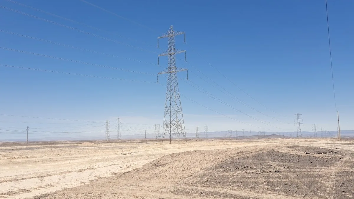 Torres y líneas de transmisión eléctrica en un paisaje desértico con escasa vegetación